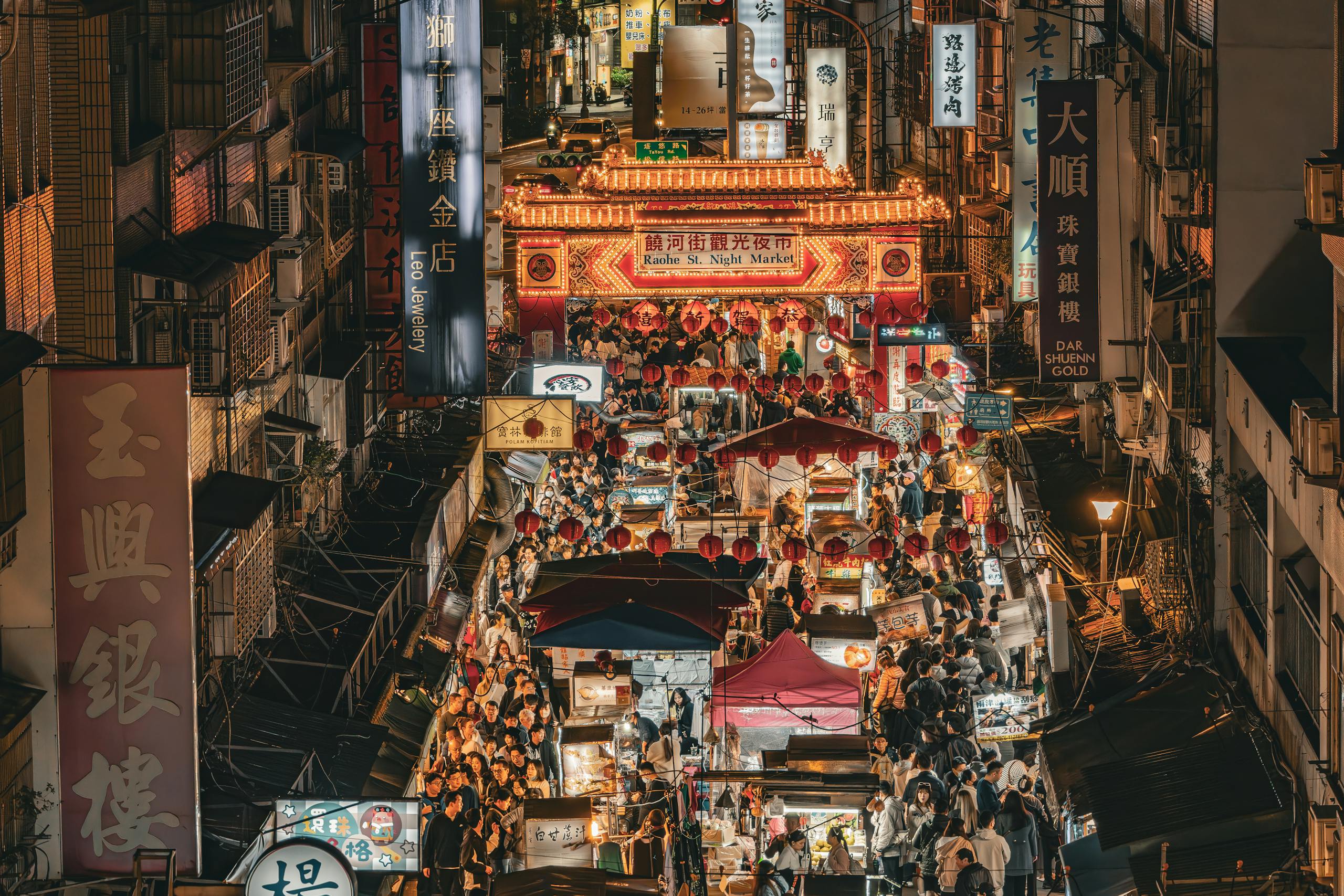 台北の饒河街夜市の賑やかな風景、活気あるストリートライフとライトアップされた屋台。